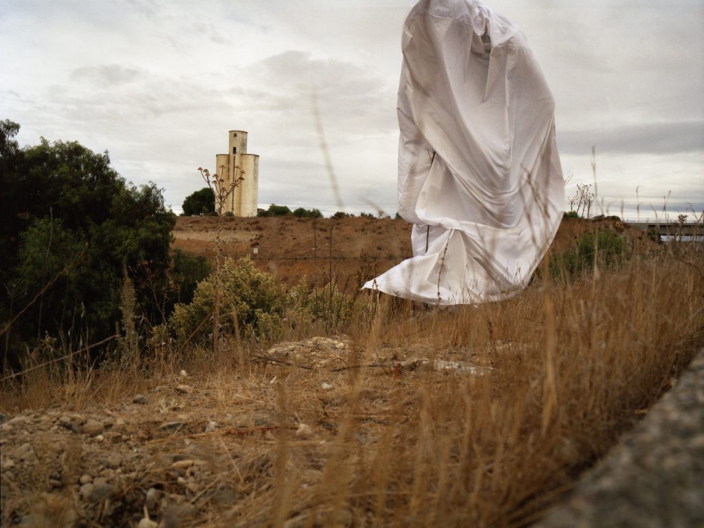 A white cloth suspended mid-air, gently billowing in an unseen breeze.