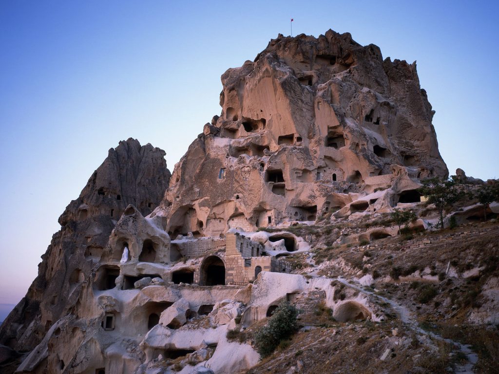 Stone houses with windows, blending seamlessly into the rocky landscape.