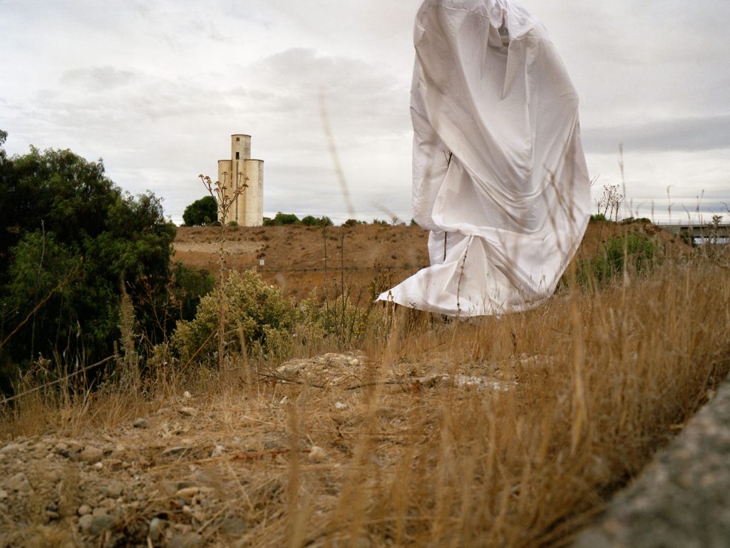 A ghostly figure in a white dress gracefully soaring through the air, exuding an ethereal presence.