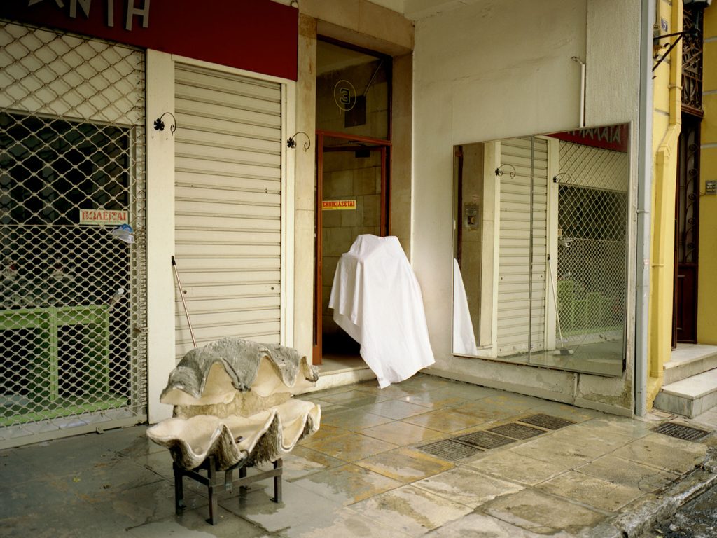 A person standing outside to the door showing a room with elegant decor and soft lighting.