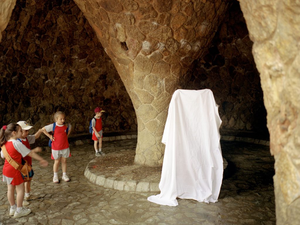 A person wearing white cloths standing on a stone floor.