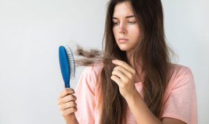 A women struggling with hair loss watching the hair brush