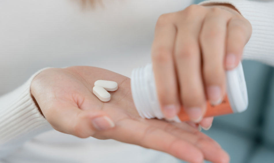 Women taking two white tablets