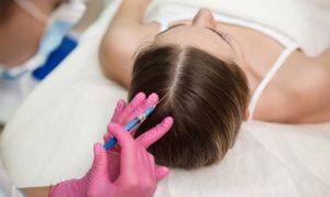 A healthcare worker injecting medicine in women scalp